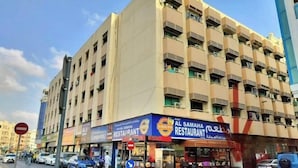 A multi-story building with a restaurant on the ground floor. - Rovers Hostel (Dubai)