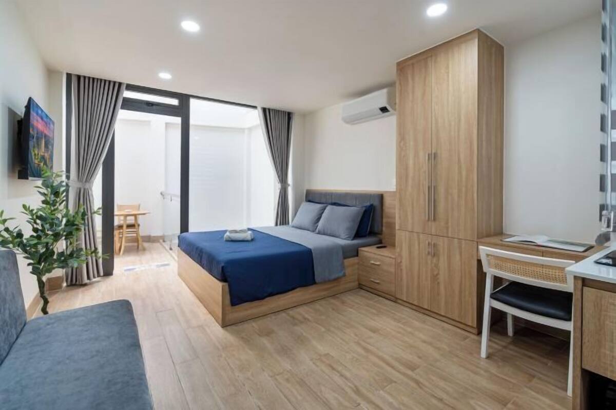 Ein modernes Schlafzimmer mit Bett, Schreibtisch, Kleiderschrank und Fenster.