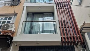 A modern building with a large window, a security camera, and a red railing. - Hearth and Home Ben Thanh (5 mins to Ben Thanh Market) (Ho Chi Minh City)
