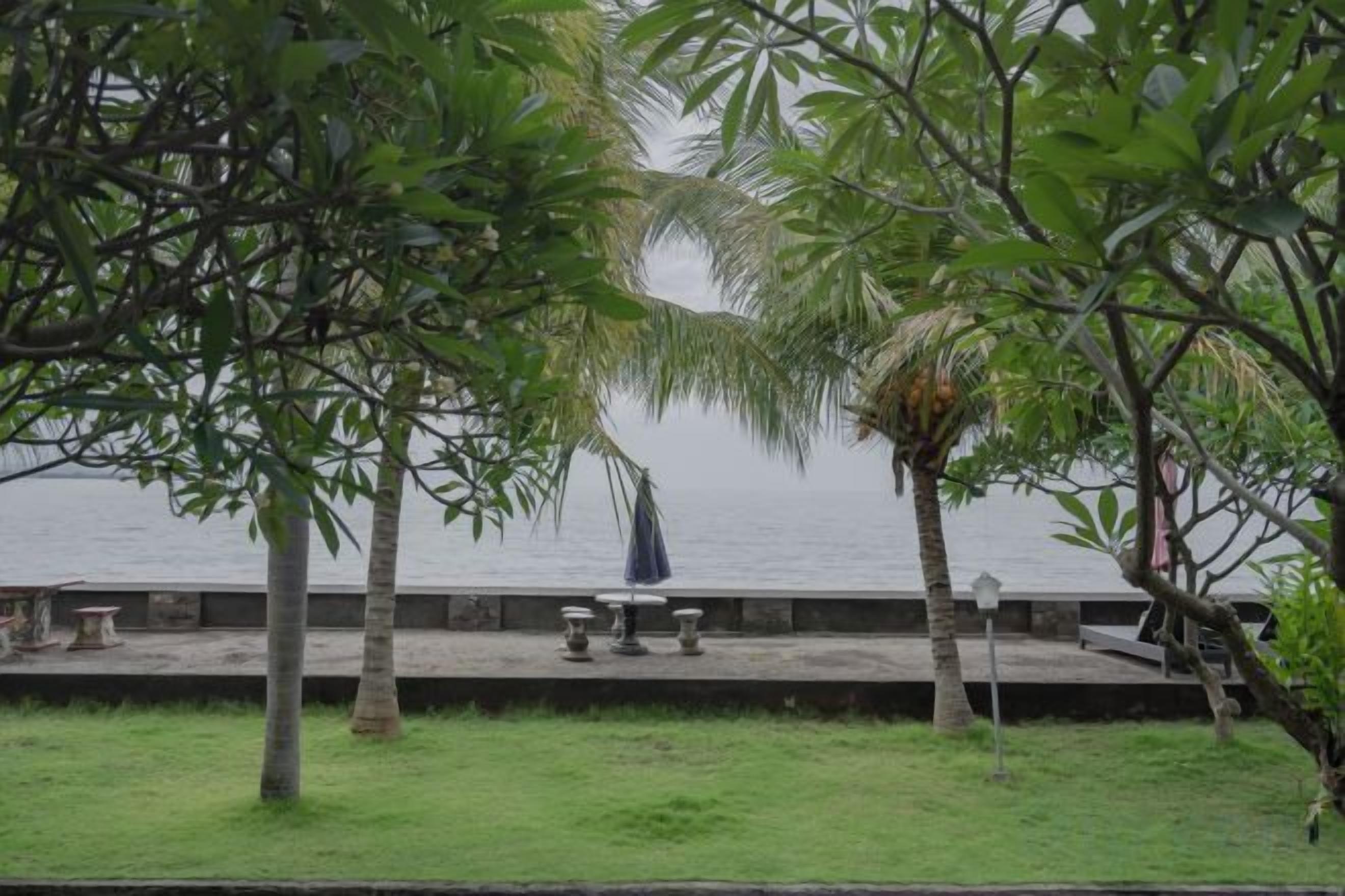 A waterfront view with a grassy area, benches, and a pathway leading to the water.