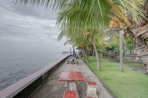 Eine Uferpromenade mit Bänken und Palmen.