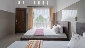 A hotel room with a large bed, a wooden wardrobe, and a window with curtains. - Rommeo Inn Lovina Mitra RedDoorz (Bali)