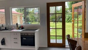 Eine Küche mit Fenster, einer Tür zum Außenbereich und einem Essbereich.