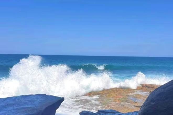 A rocky shoreline with waves crashing against the rocks.