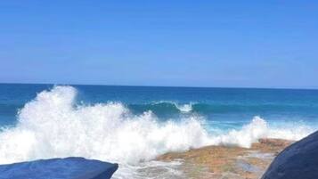A rocky shoreline with waves crashing against the rocks.
