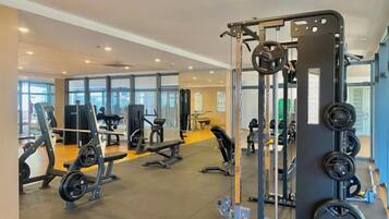 Ein Fitnessstudio mit Krafttrainingsgeräten, Bänken und Cardiogeräten.