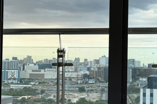 En stadsbild sedd genom ett fönster, med utsikt över byggnader och byggnadsarbete.