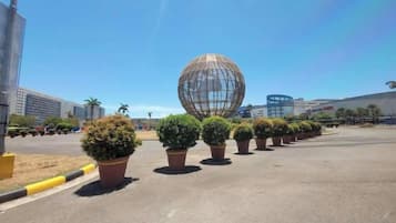 A parking lot with potted plants and a large spherical structure.