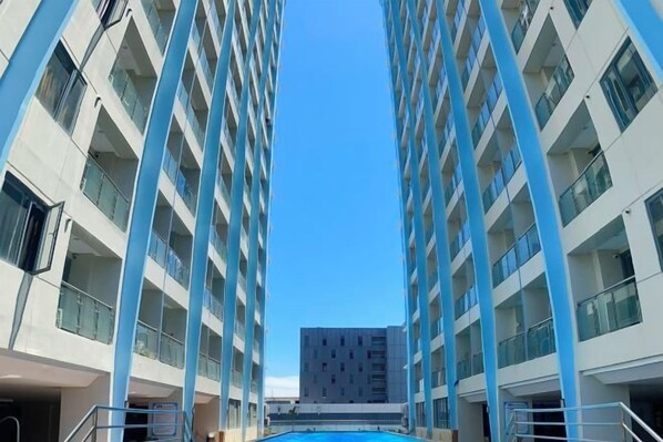 Un edificio de gran altura con un atrio central y una piscina en la planta baja.