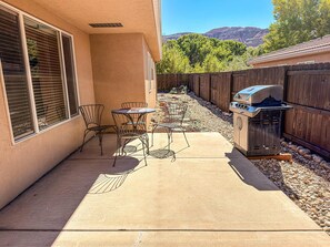 A patio with a grill, chairs, and a table. - Leisure Space - 327 (Moab)