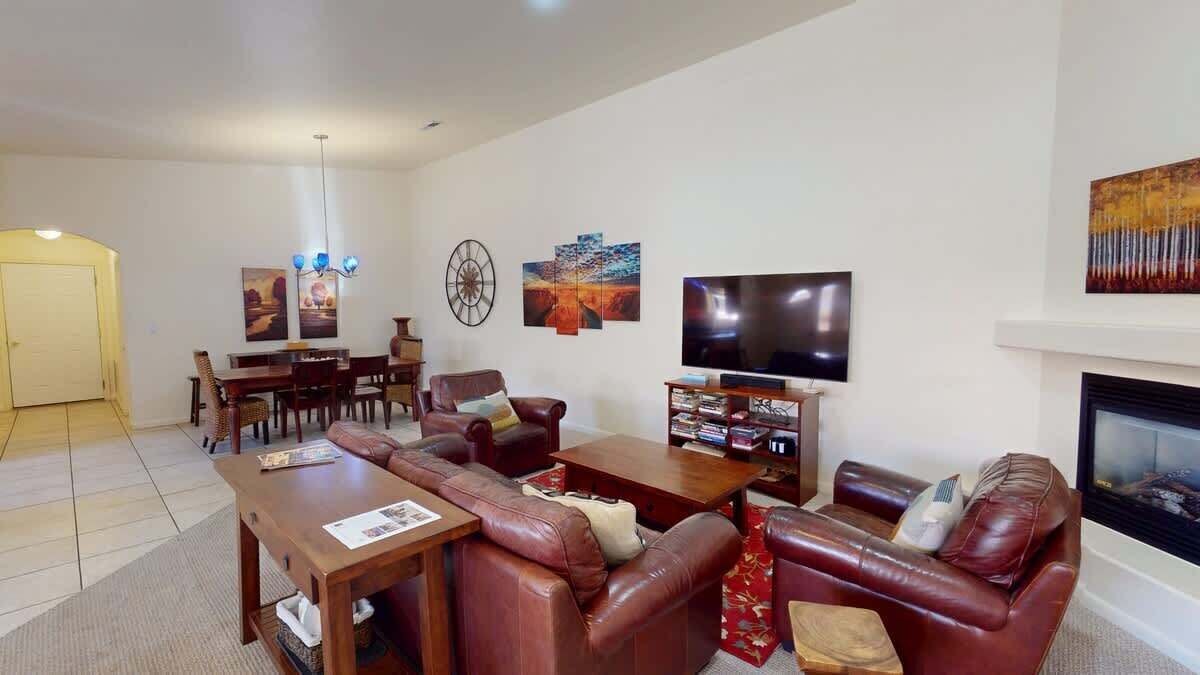 A living room with a fireplace, a television, and a dining area.