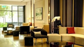 A modern lobby with a mix of seating options, including sofas and chairs, arranged around a central coffee table. - A Quiet Stay - Service Apartment, Vinhome Ocean Park, Ha Noi (Hanoi)