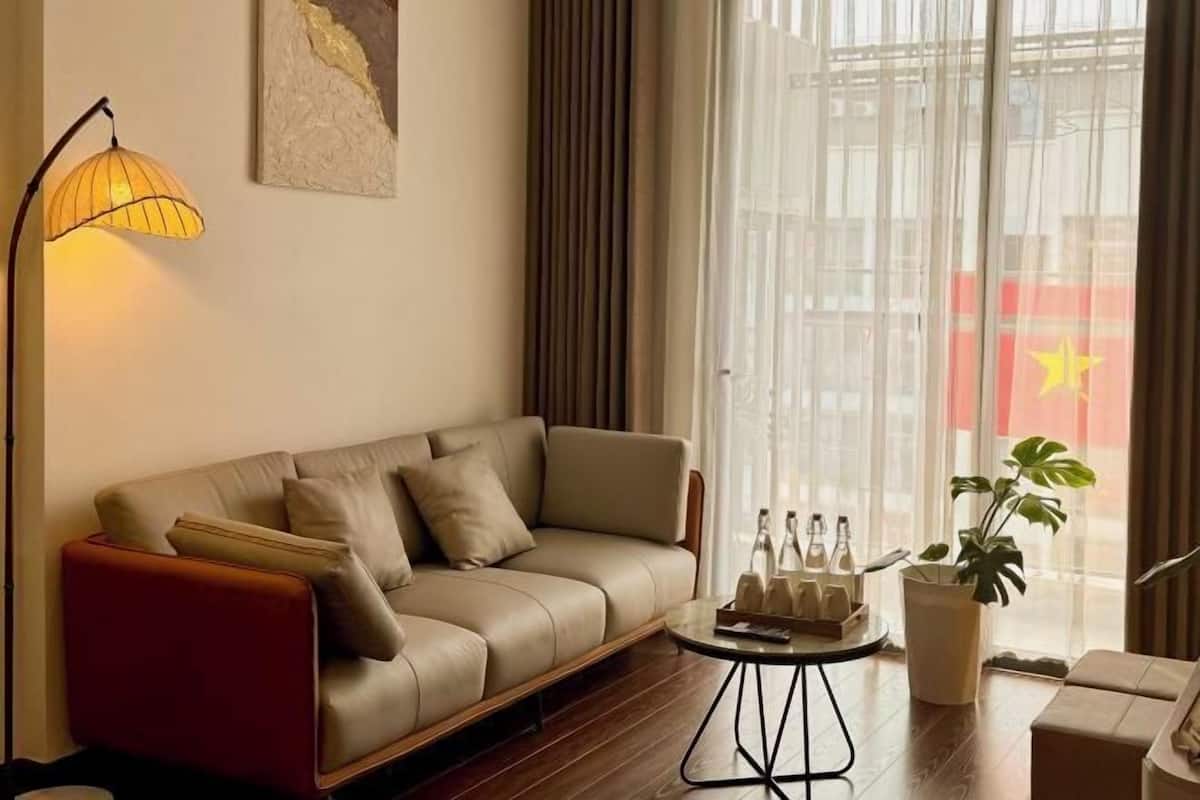 Un salon moderne avec un canapé, une lampe, une table basse et une plante.