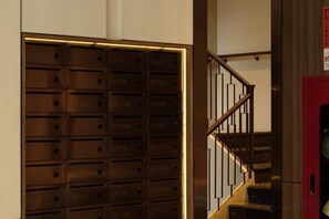 A staircase with a metal railing and a wall-mounted mailbox with numbered slots. - A Quiet Stay - Service Apartment, Vinhome Ocean Park, Ha Noi (Hanoi)