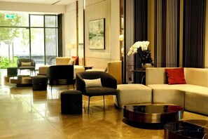A modern lobby with seating arrangements, a coffee table, and a decorative vase. - A Quiet Stay - Service Apartment, Vinhome Ocean Park, Ha Noi (Hanoi)