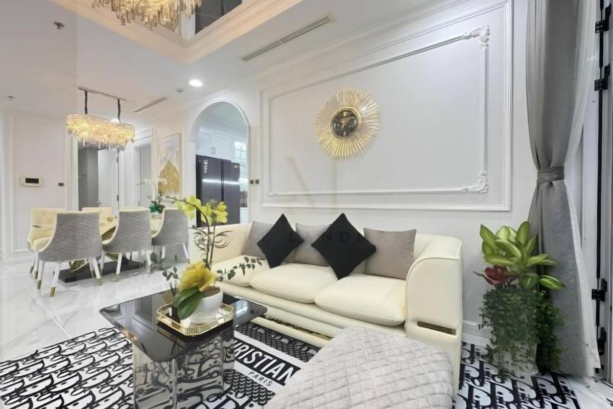 Una sala moderna con un sofá blanco, una mesa de centro con estampado blanco y negro, y un candelabro.