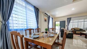 A dining area with a wooden table set for six, surrounded by chairs. - Riverside Lot No.1 Homestay at Kota Kinabalu (Putatan)