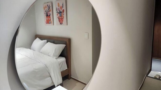 Une chambre à coucher avec un lit, une tête de lit et deux œuvres d’art accrochées au mur.