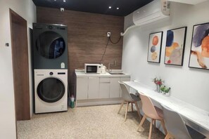 A compact kitchen with a washing machine, microwave, and sink. - Stay plan (Incheon)
