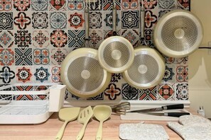 A kitchen with patterned tiles, a set of plates, a cutting board, and utensils. - 3 Bedroom NORDIC HOME Full Kitchen 8 MINS to MRT & JODD Fair (Bangkok)