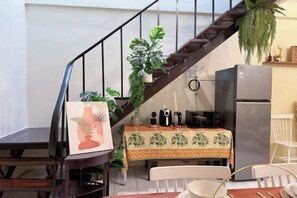 A kitchen with a staircase, a dining table with chairs, a refrigerator, and a potted plant. - 3 Bedroom NORDIC HOME Full Kitchen 8 MINS to MRT & JODD Fair (Bangkok)
