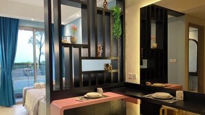 Een moderne hotelkamer met kitchenette, een bed met uitzicht en een eethoek met krukken.