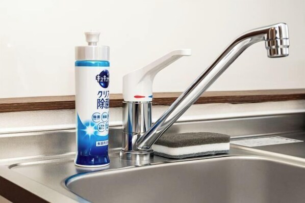 A stainless steel sink with a chrome faucet and a soap dispenser.
