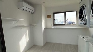 A laundry room with a window, a washing machine, and a dryer. - OHAYO Hotel・Kami-Itabash (Tokyo)
