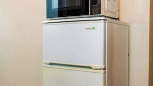 A white refrigerator with a freezer compartment on top, a control panel, and a small logo on the door. - OHAYO Hotel・Kami-Itabash (Tokyo)