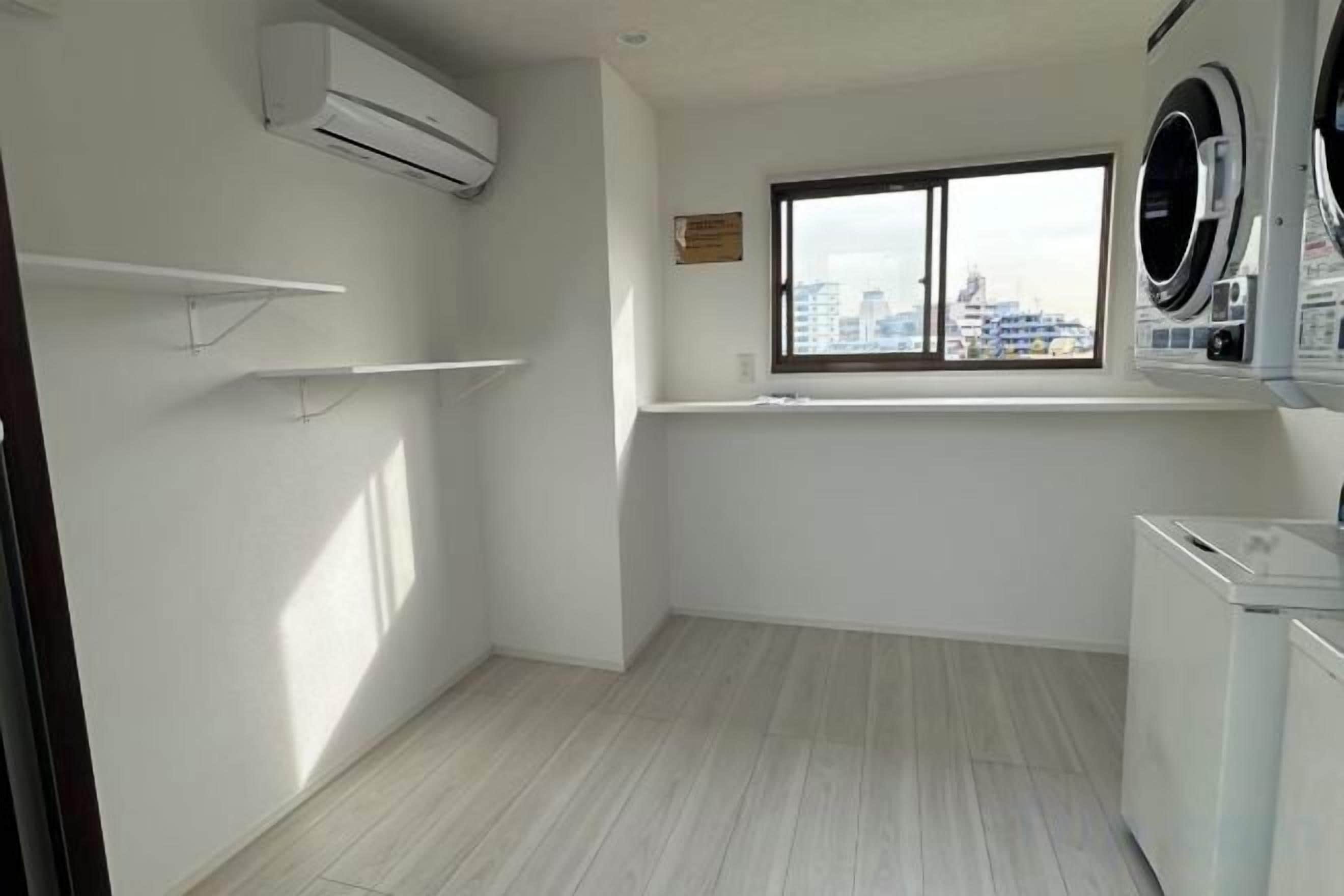 A laundry room with a window, a washing machine, and a dryer.