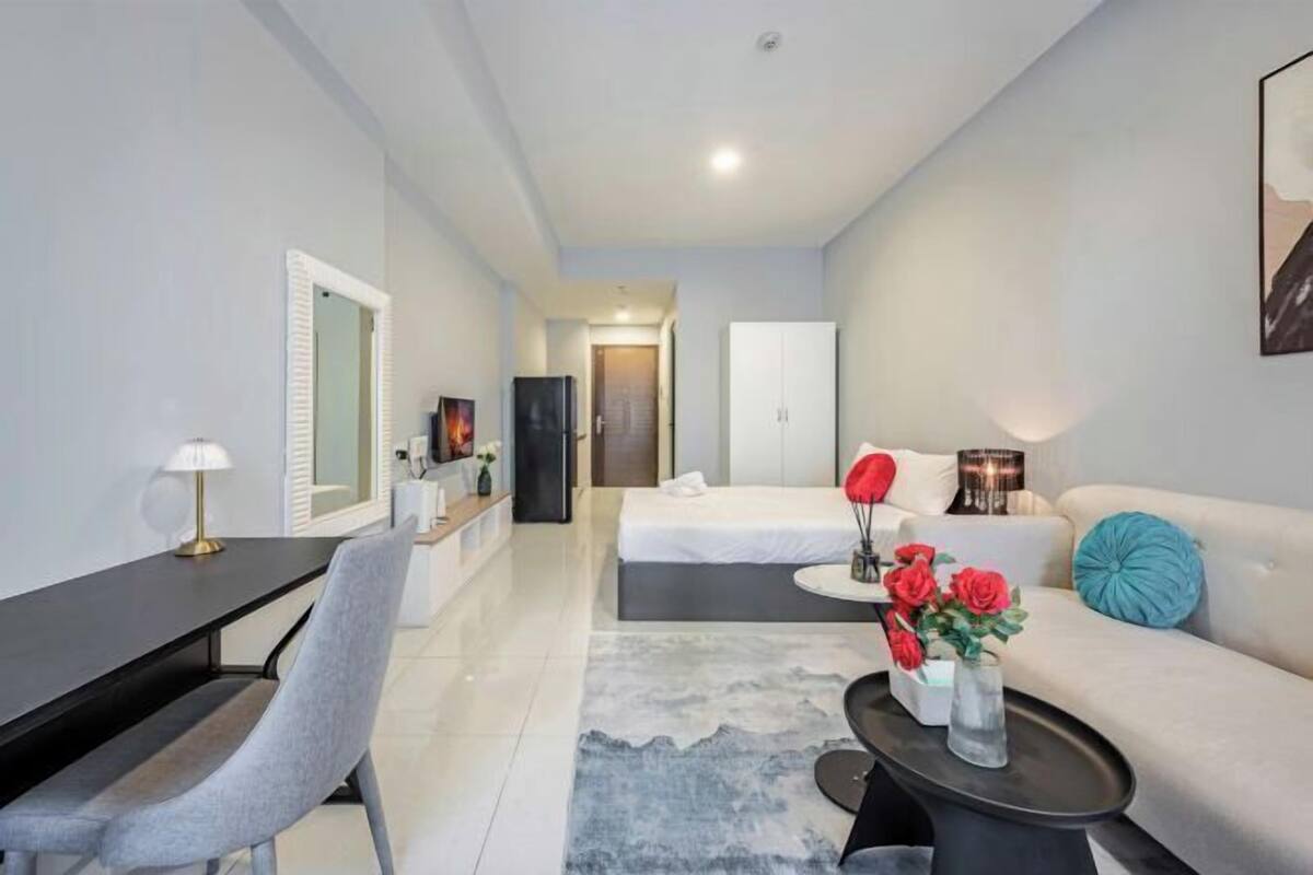 Une chambre d’hôtel moderne équipée d’un lit, d’un bureau, d’une chaise, d’un canapé et d’une table basse.
