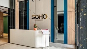 A reception desk with a sign reading "SOHO RESIDENCE" in a modern building with a clean, minimalist design. - SOHO Tower Apartment Hotel (Ho Chi Minh City)
