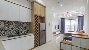 A modern kitchen with white cabinets, a built-in wine rack, and a stainless steel refrigerator. - SOHO Tower Apartment Hotel (Ho Chi Minh City)