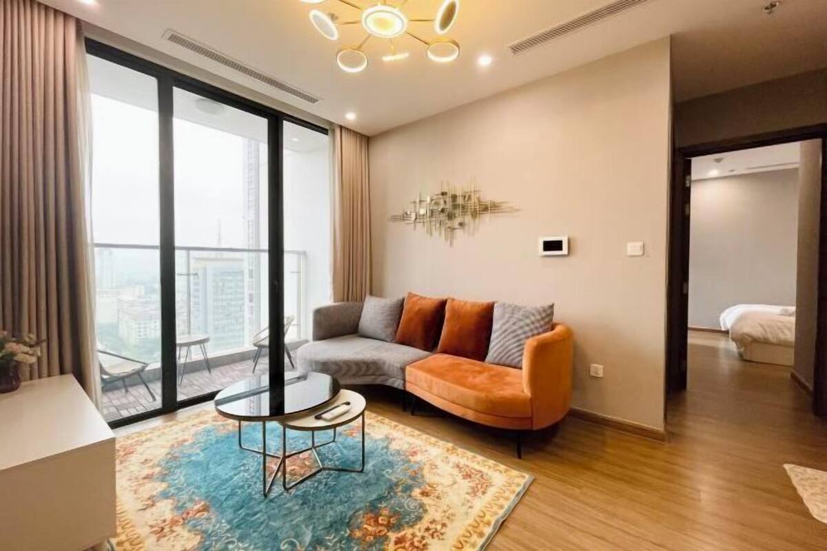 Uma sala de estar moderna com um sofá, uma mesa de centro e uma janela grande.