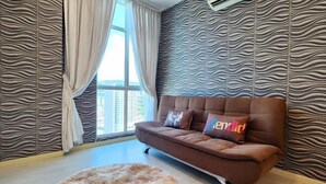 Een moderne woonkamer met een bruine bank, behang met een patroon, een rond tapijt en een groot raam met gordijnen.