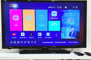 A flat-screen TV displaying a user interface with various app icons and a QR code. - Modern Suite in Penang Island (George Town)
