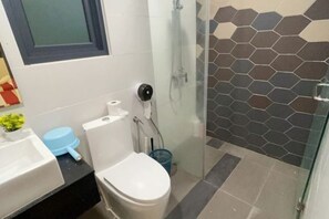 Une salle de bain avec des toilettes, un lavabo et une douche.