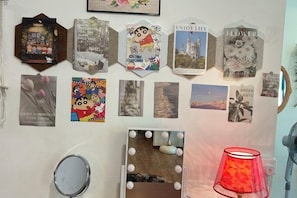 Una pared decorada con varias fotografías enmarcadas y un espejo de tocador con luces.