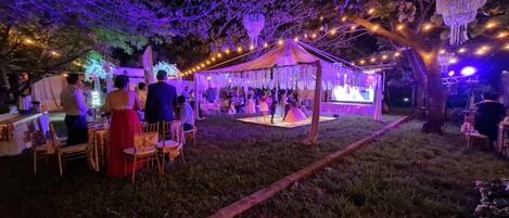 An outdoor event with a tent and string lights.