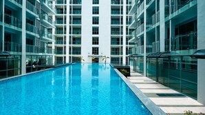 Um edifício moderno com piscina central, janelas amplas e um design contemporâneo e elegante.
