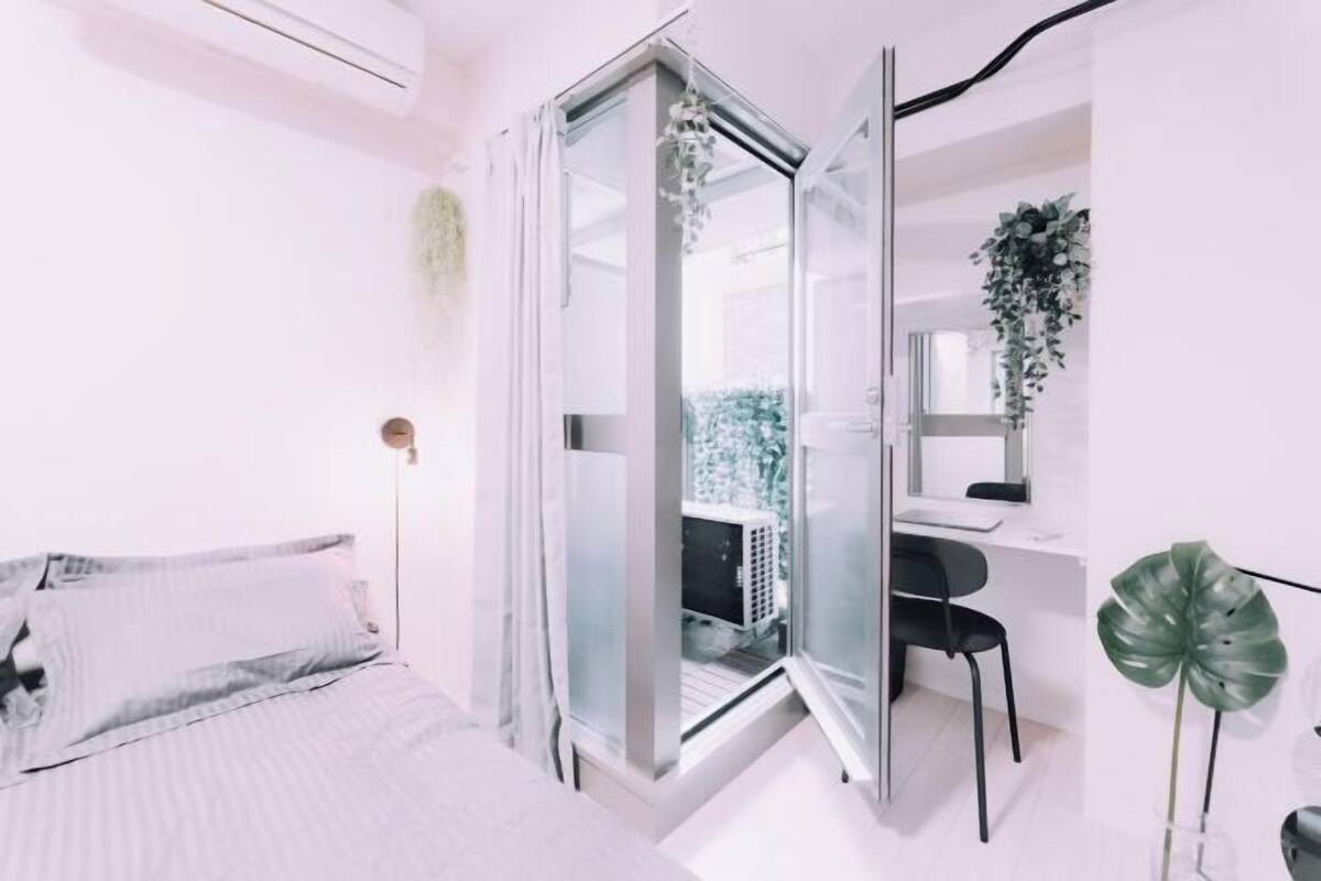 A bedroom with a bed, a desk, and a chair.