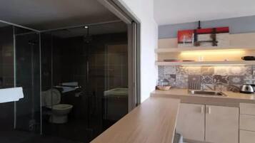 Une cuisine moderne dotée d’un plan de travail en bois, d’un évier et d’un pare-feu en carreaux.