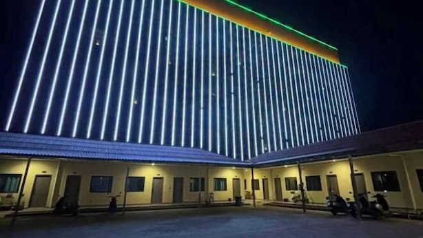 A hotel with a modern design, featuring vertical light strips on the facade and a covered parking area. - Dong 'Du Da Jiu Dian (Vientiane)