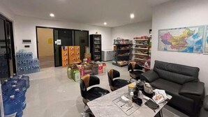 A hotel room with a dining area, a sofa, a table with various items, and a map on the wall. - Dong 'Du Da Jiu Dian (Vientiane)