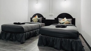 A room with two beds, each with a black headboard and matching skirted footboard. - White House (Ko Phi Phi)