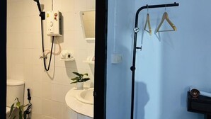 A bathroom with a shower, toilet, sink, and a towel rack. - White House (Ko Phi Phi)