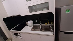 Een kleine keuken met een inbouwgootsteen, een broodrooster en een koelkast.