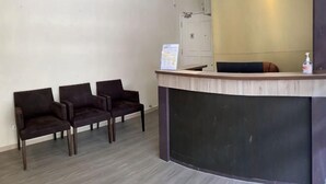 A reception area with a counter, two chairs, and a sign on the wall.