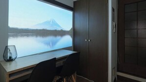 A room with a large window, a desk, two chairs, and a dark wooden wardrobe. - Garden Otsuka (Tokyo)