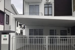 A modern building with a gated entrance, multiple windows, and a balcony.